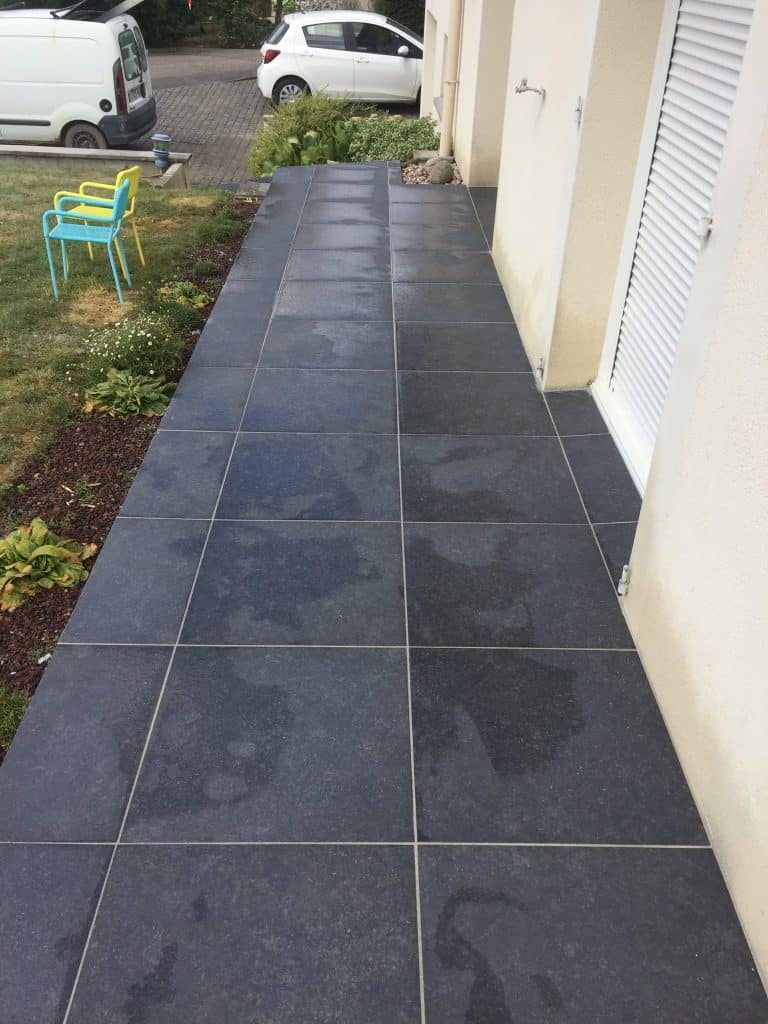 Terrasse en grandes dalles sombres le long de la maison